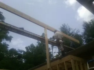 Carpenter setting a ridge beam over a new addition frame — Ice Dam Removal by Roofing Brothers in Bloomville