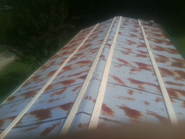 Rusted metal roof panels with new wood purlins before replacement — Storm Damage Roof Repair in Bloomville by Roofing Brothers