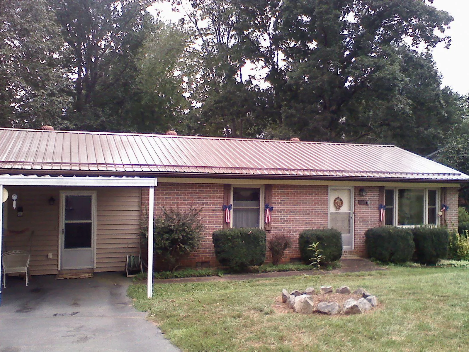 Bronze metal roof and carport on a brick ranch home — Roof Repair work by our crew in Bloomville